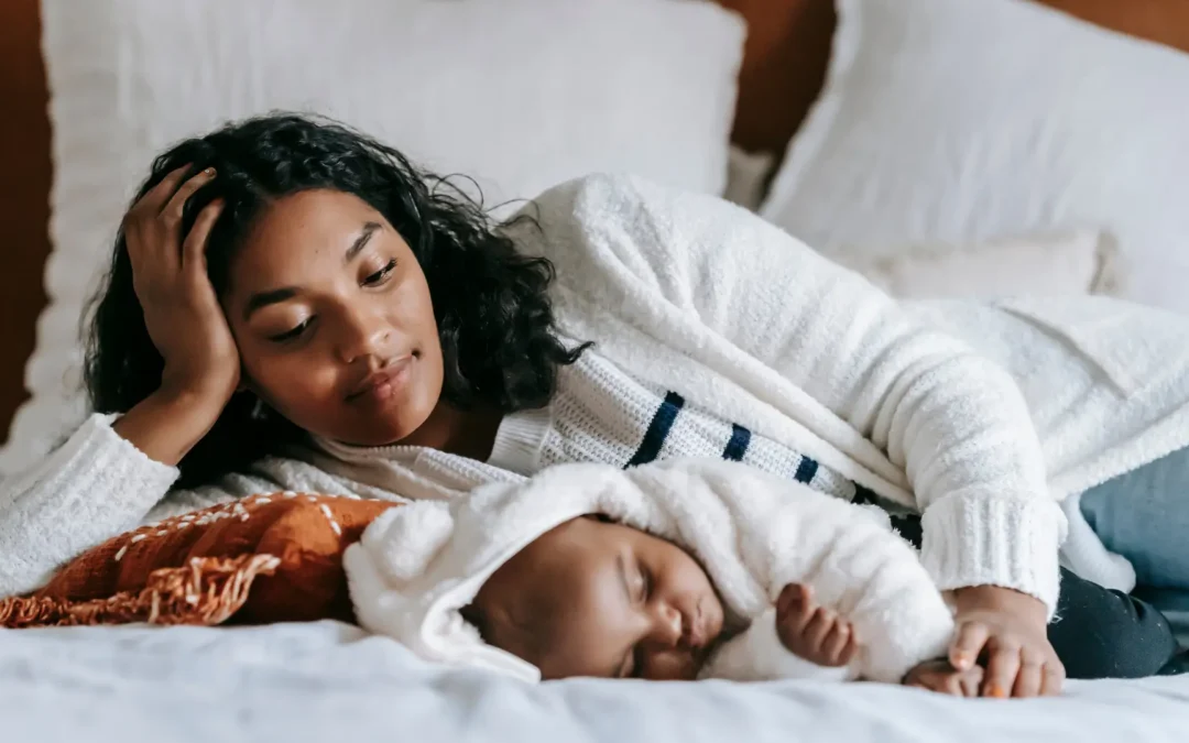 Mère se posant des questions à côté de son enfant endormi, comprendre le sommeil de son enfant
