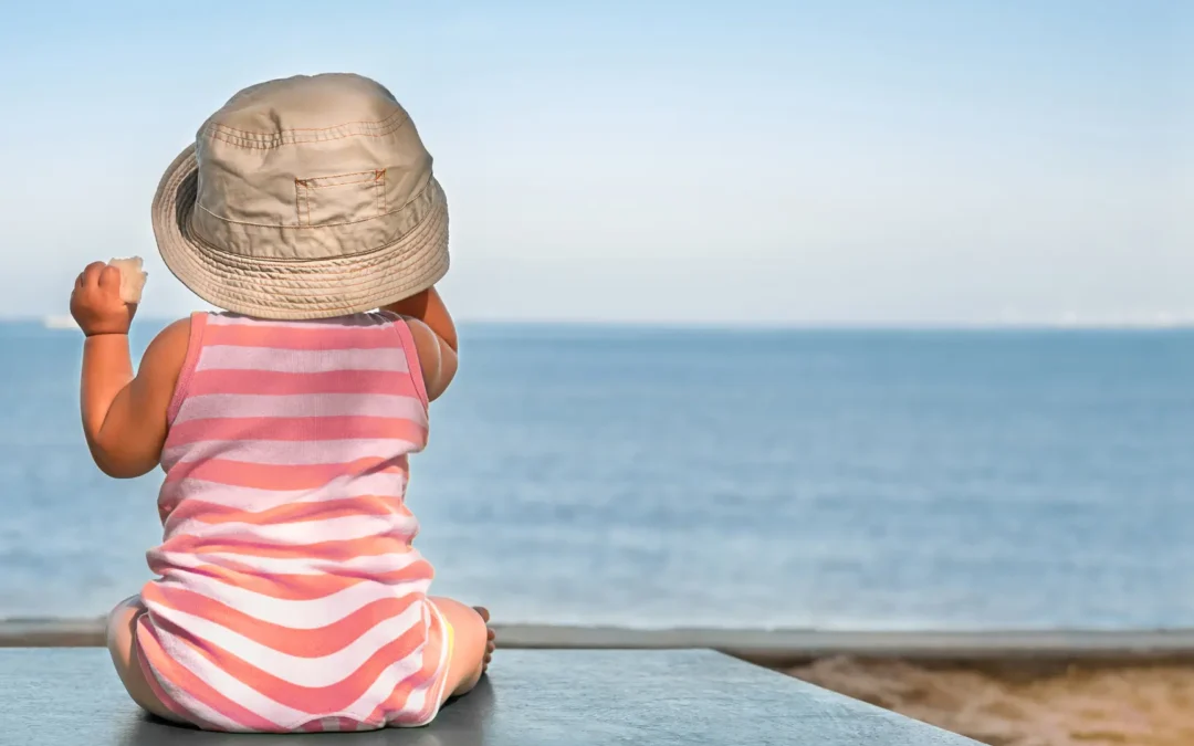 Bébé assis face à la mer, sommeil de bébé pendant les grandes vacances
